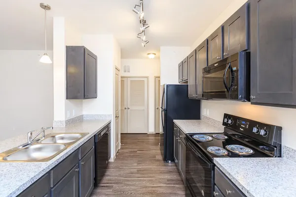 a kitchen with stainless steel appliances granite countertop a sink stove and refrigerator
