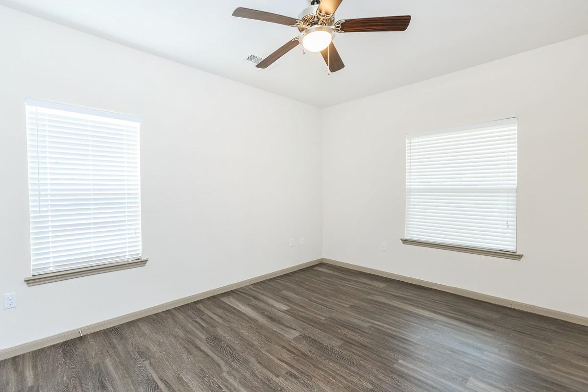 8501 Casa Verde Road, Unit 20 Laredo, TX 78041 - Photo 6 of 6 an empty room with wooden floor windows and fan