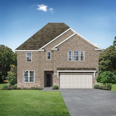 a front view of a house with a garden and yard