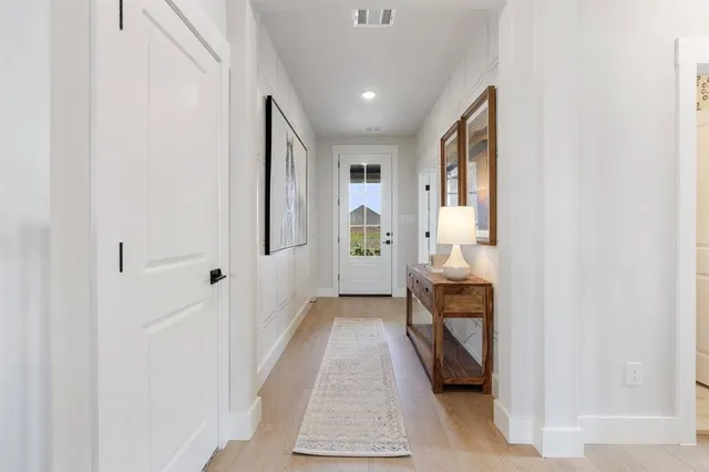 a view of hallway with wooden floor and chair