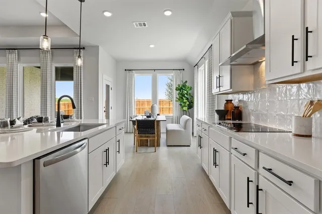 a kitchen with counter top space a sink appliances and cabinets