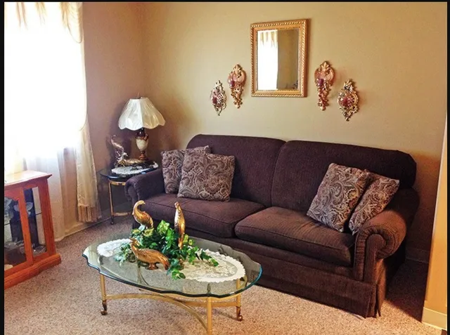 a living room with furniture flowerpot and wooden floor