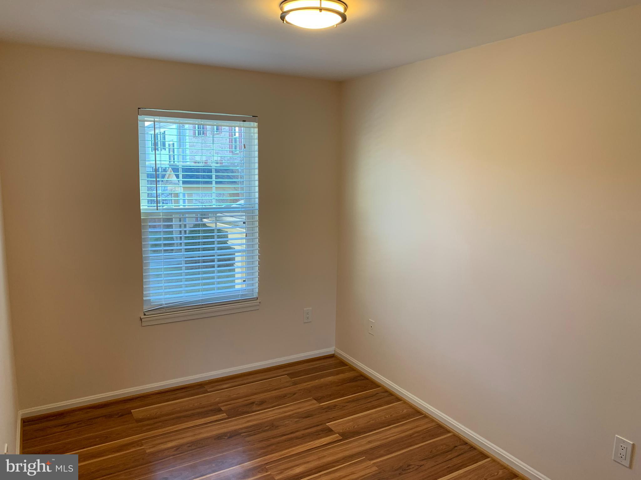 2 Normandy Square Court, Unit D Silver Spring, MD 20906 - Photo 15 of 23 a view of an empty room with wooden floor and a window