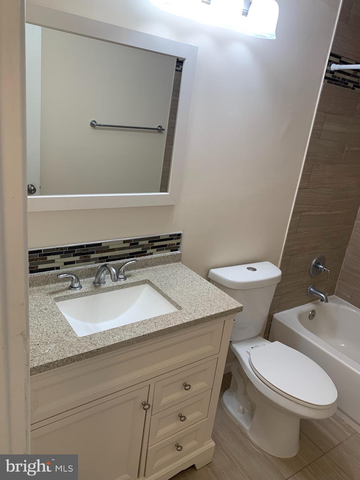 2 Normandy Square Court, Unit D Silver Spring, MD 20906 - Photo 17 of 23 a bathroom with a granite countertop toilet sink and mirror