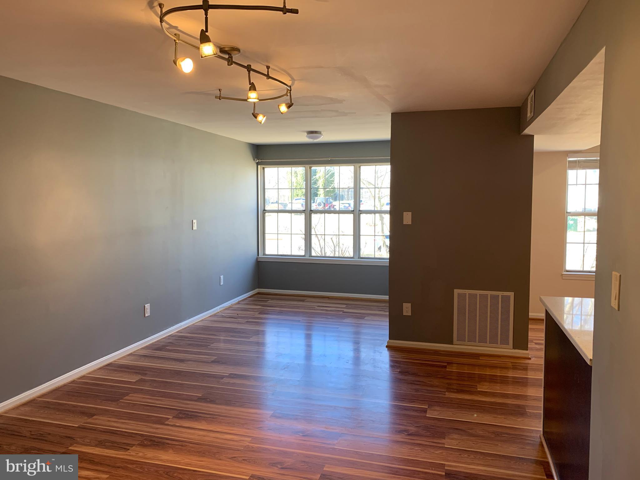2 Normandy Square Court, Unit D Silver Spring, MD 20906 - Photo 3 of 23 a view of an empty room with wooden floor and a window