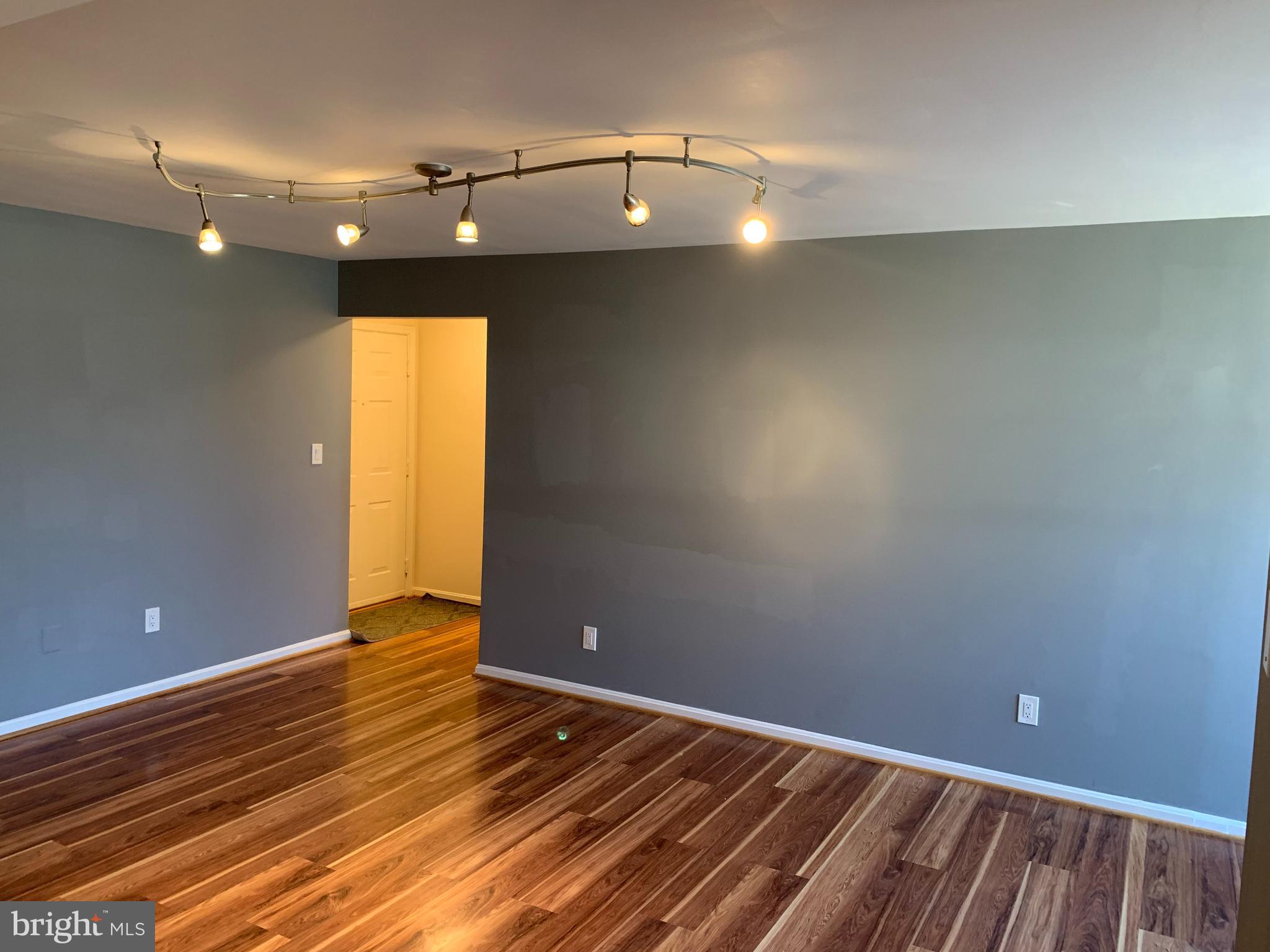 2 Normandy Square Court, Unit D Silver Spring, MD 20906 - Photo 5 of 23 a view of an empty room with wooden floor and a chandelier