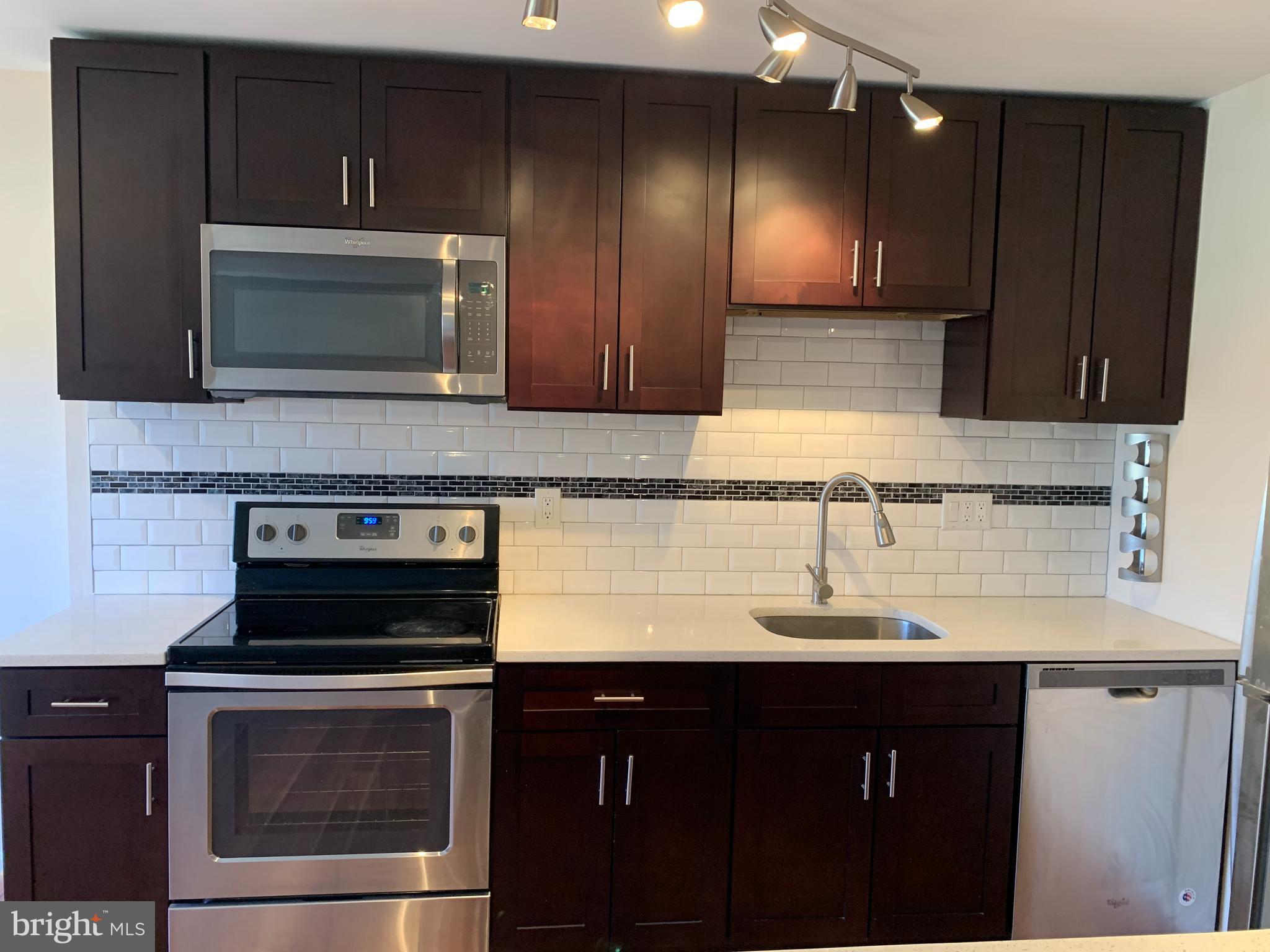 2 Normandy Square Court, Unit D Silver Spring, MD 20906 - Photo 6 of 23 a kitchen with granite countertop a stove microwave and sink