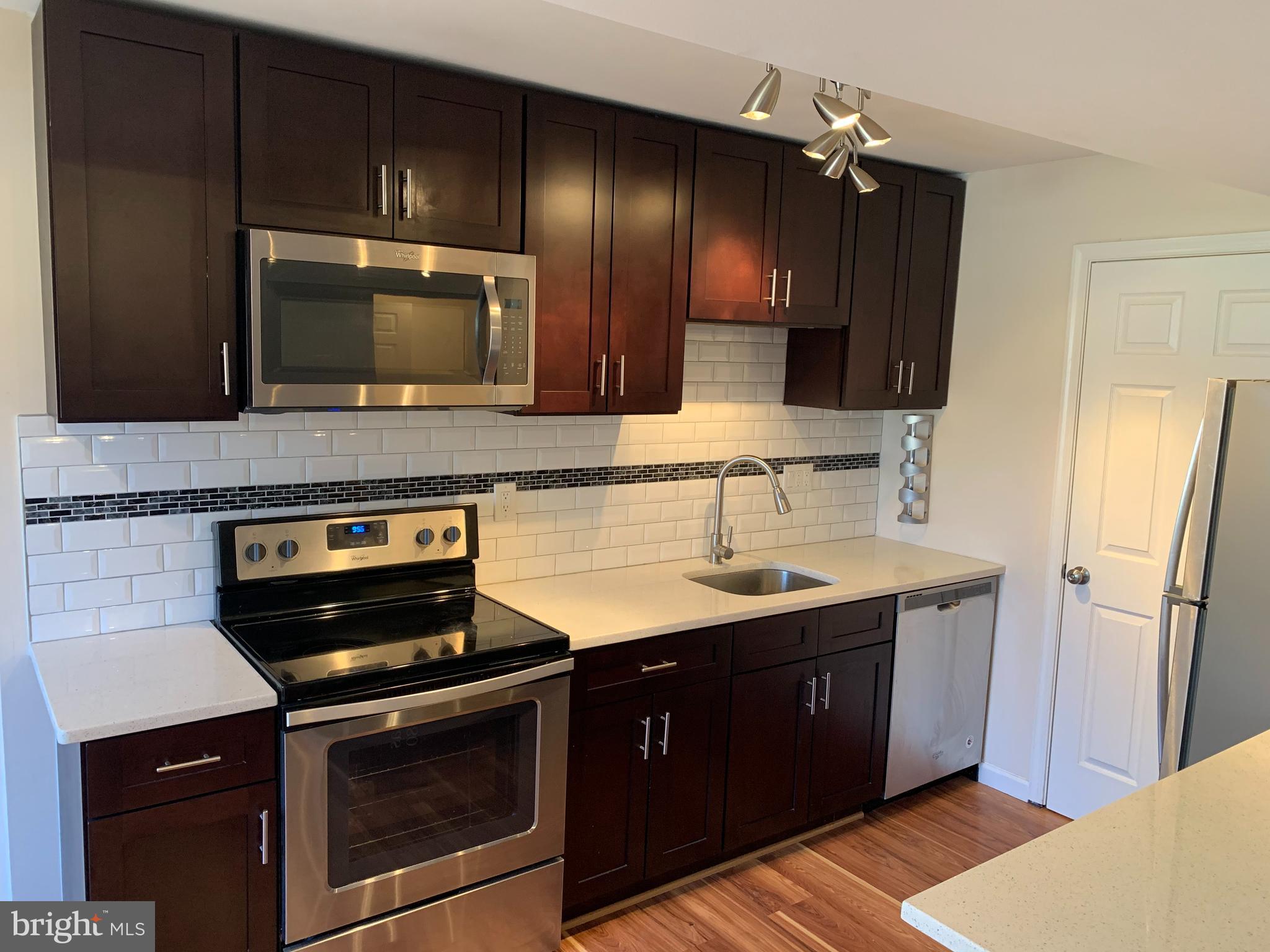 2 Normandy Square Court, Unit D Silver Spring, MD 20906 - Photo 8 of 23 a kitchen with a sink and a refrigerator