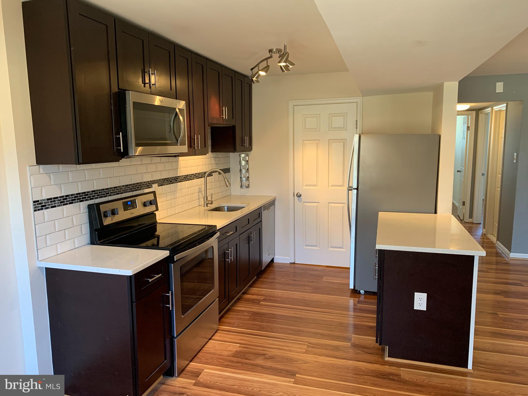 2 Normandy Square Court, Unit D Silver Spring, MD 20906 - Photo 9 of 23 a kitchen with stainless steel appliances granite countertop a sink stove and refrigerator
