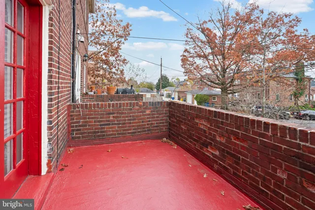 a view of a roof deck with wooden fence and large trees