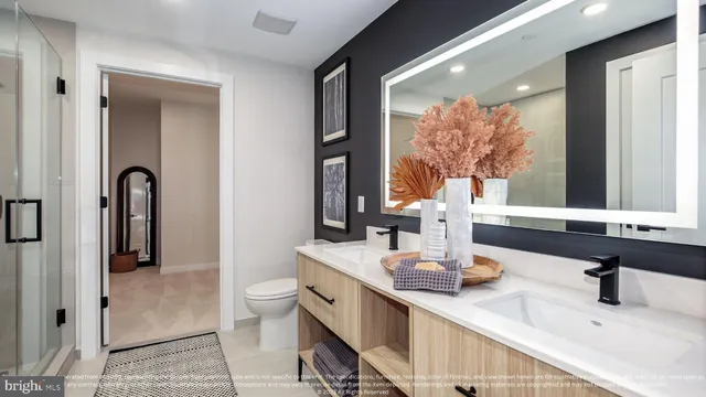 a bathroom with a double vanity sink toilet and mirror