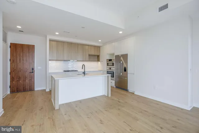 a kitchen with a refrigerator and white cabinets