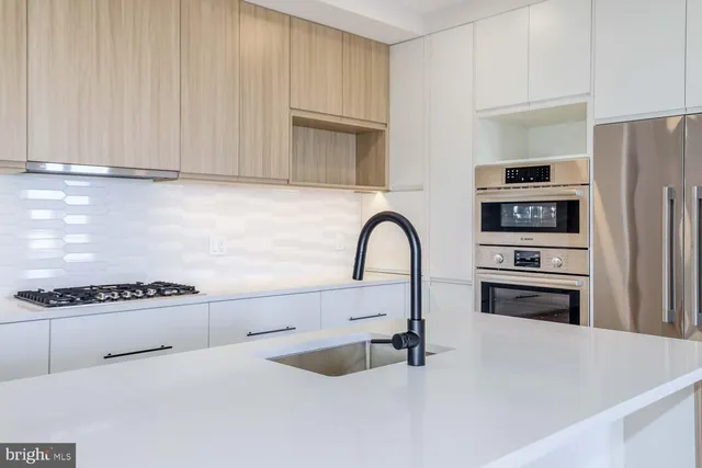 a kitchen with granite countertop a stove and a refrigerator with wooden floor