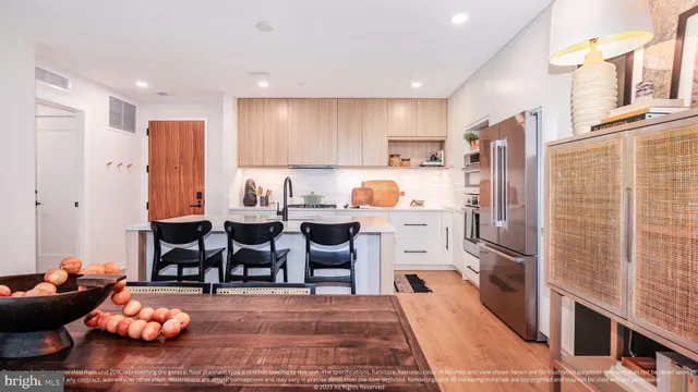 a open kitchen with stainless steel appliances granite countertop a refrigerator dining table and chairs
