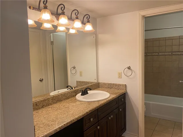 a bathroom with a granite countertop sink and a mirror