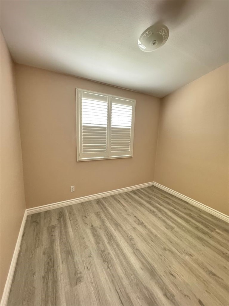 3338 Vance Street Riverside, CA 92504 - Photo 4 of 11 an empty room with wooden floor and windows