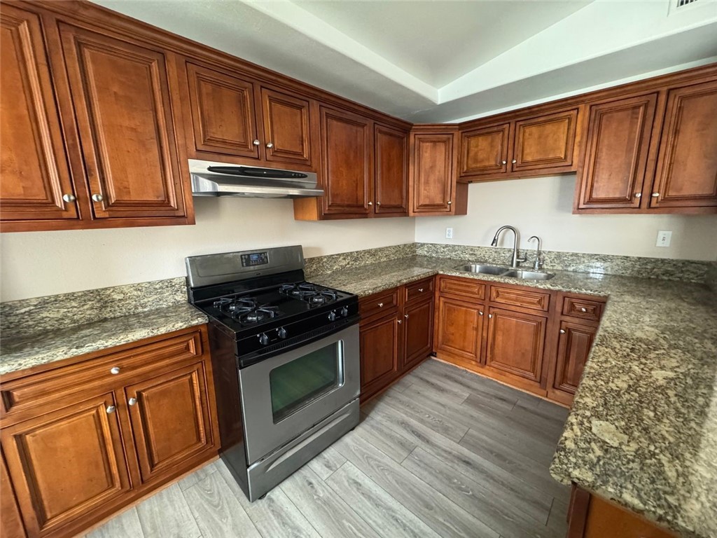 3338 Vance Street Riverside, CA 92504 - Photo 7 of 11 a kitchen with granite countertop wood cabinets stainless steel appliances and a sink