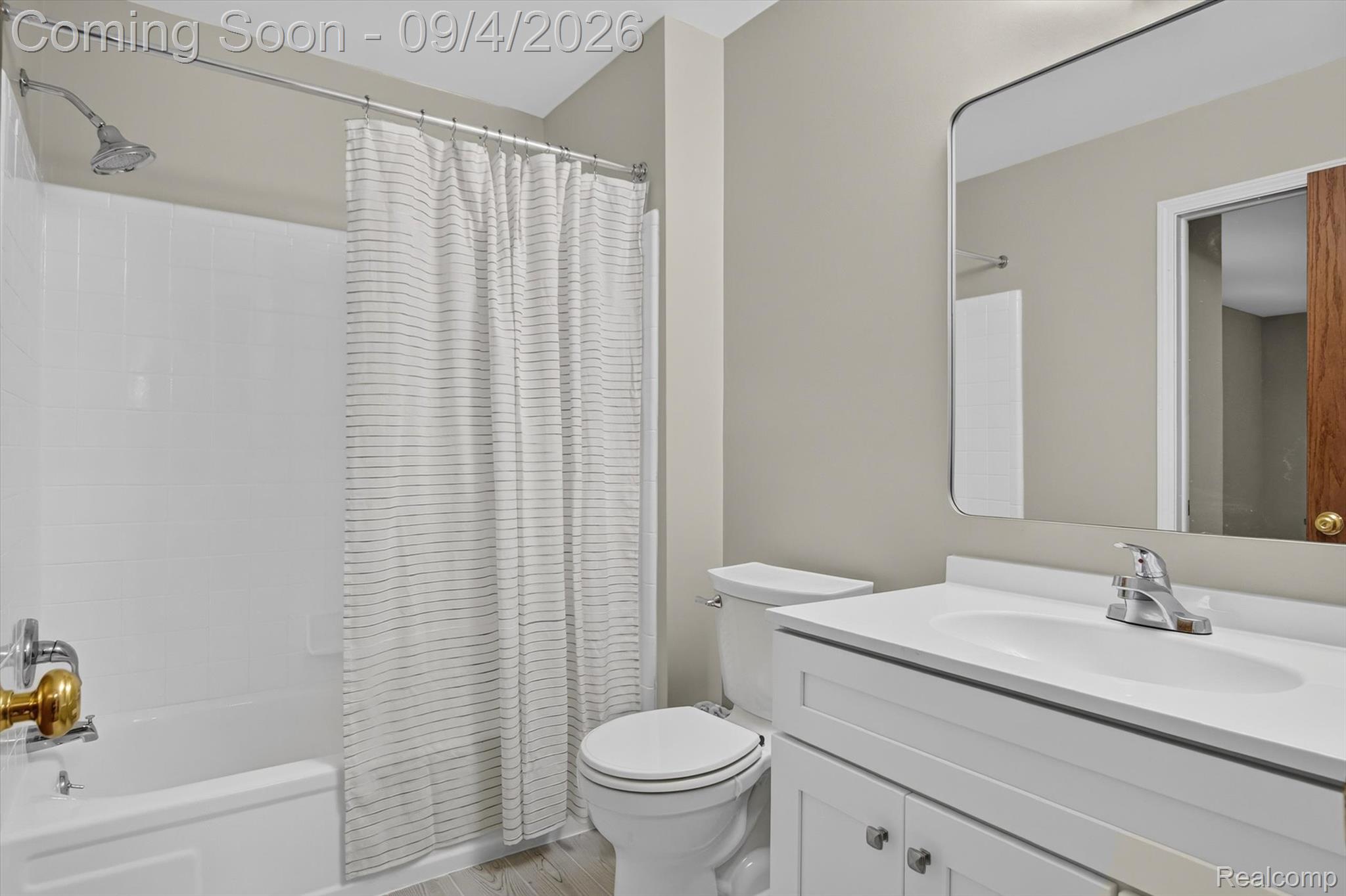 43182 Applewood Road Canton, MI 48188 - Photo 25 of 36 Bathtub with white subway tile surround, chrome shower head, white vanity with integrated sink, and wood-finish flooring
