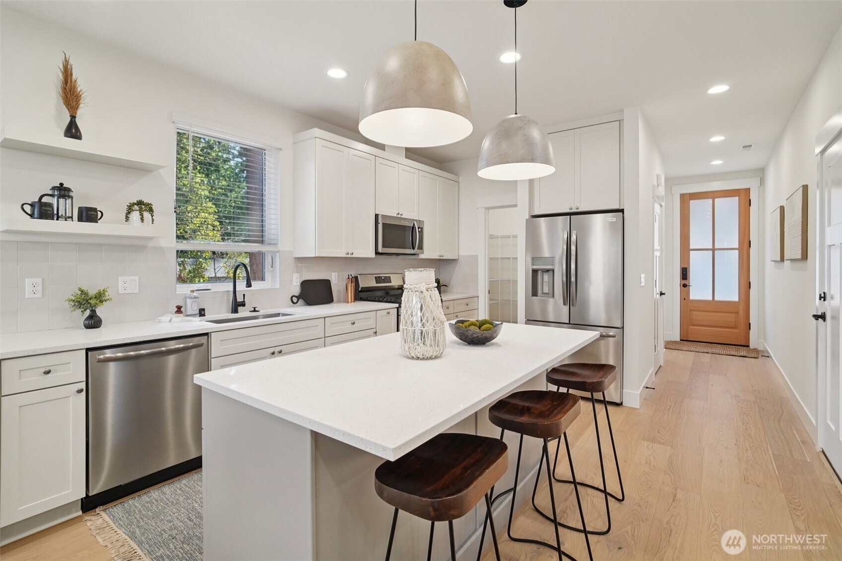 8014 222nd Street Southwest Edmonds, WA 98026 - Photo 2 of 29 a kitchen with stainless steel appliances granite countertop a sink a stove a refrigerator cabinets and a dining table with wooden floor
