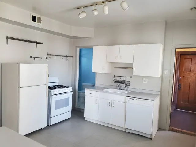 a kitchen with white cabinets and white appliances