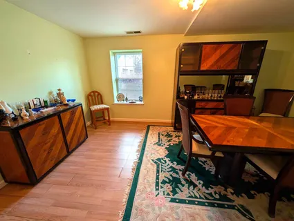 a room with wooden floor pool table and windows
