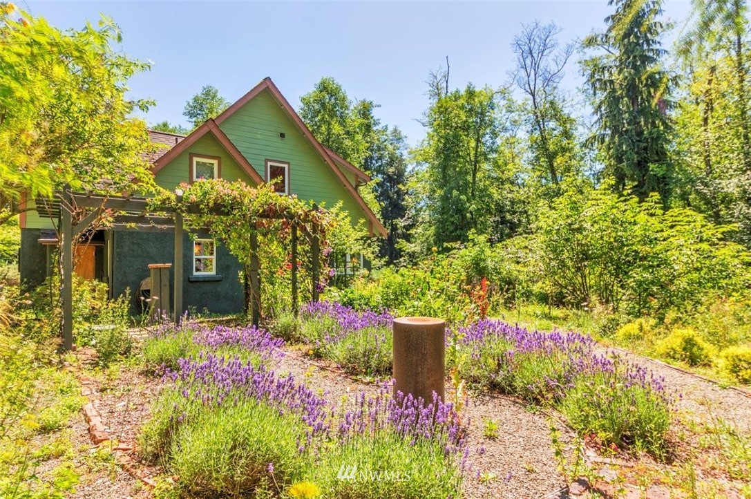 105 Naylor Creek Road Chimacum, WA 98325 - Photo 4 of 24 a front view of a house with a yard and flowers
