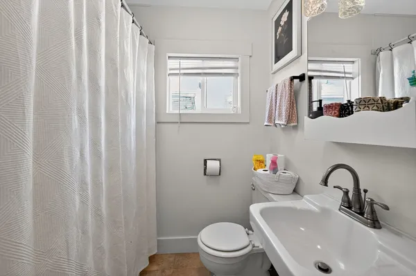 a bathroom with a sink a toilet and shower curtain