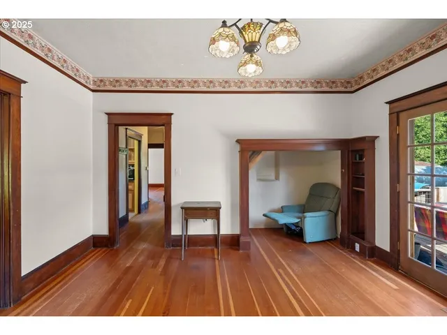 a view of empty room with wooden floor