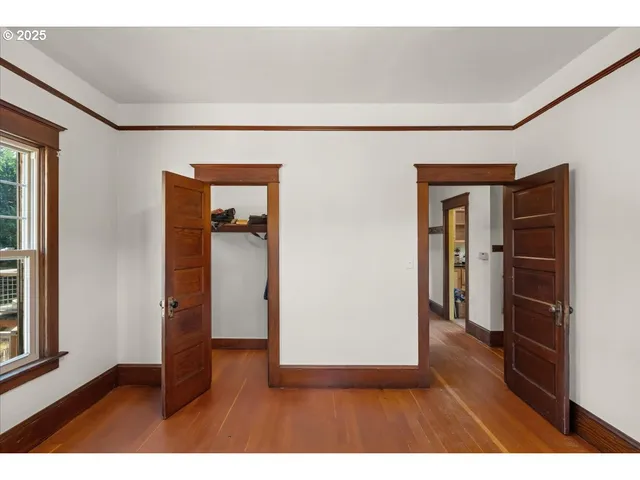 a view of a hallway with wooden floor and closet