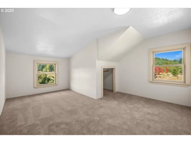 a view of an empty room with window and closet