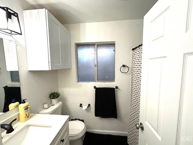 a bathroom with a toilet a sink and a mirror