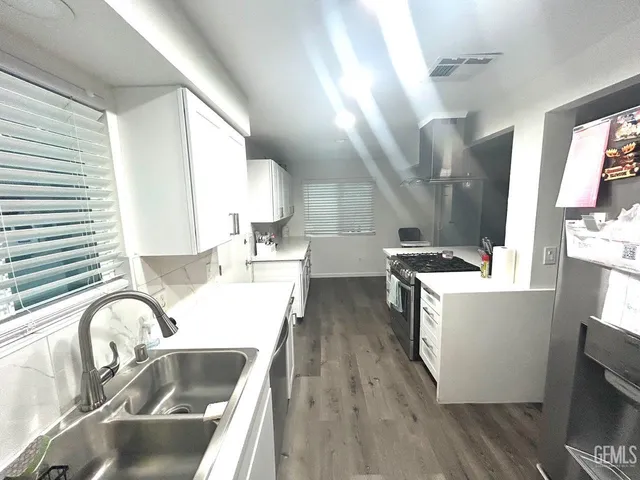 a kitchen with kitchen island a sink wooden floor and counter top space