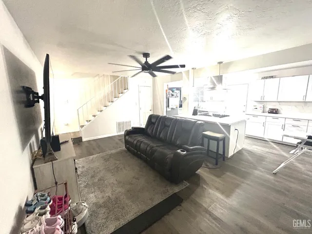 a living room with furniture a flat screen tv and a large window