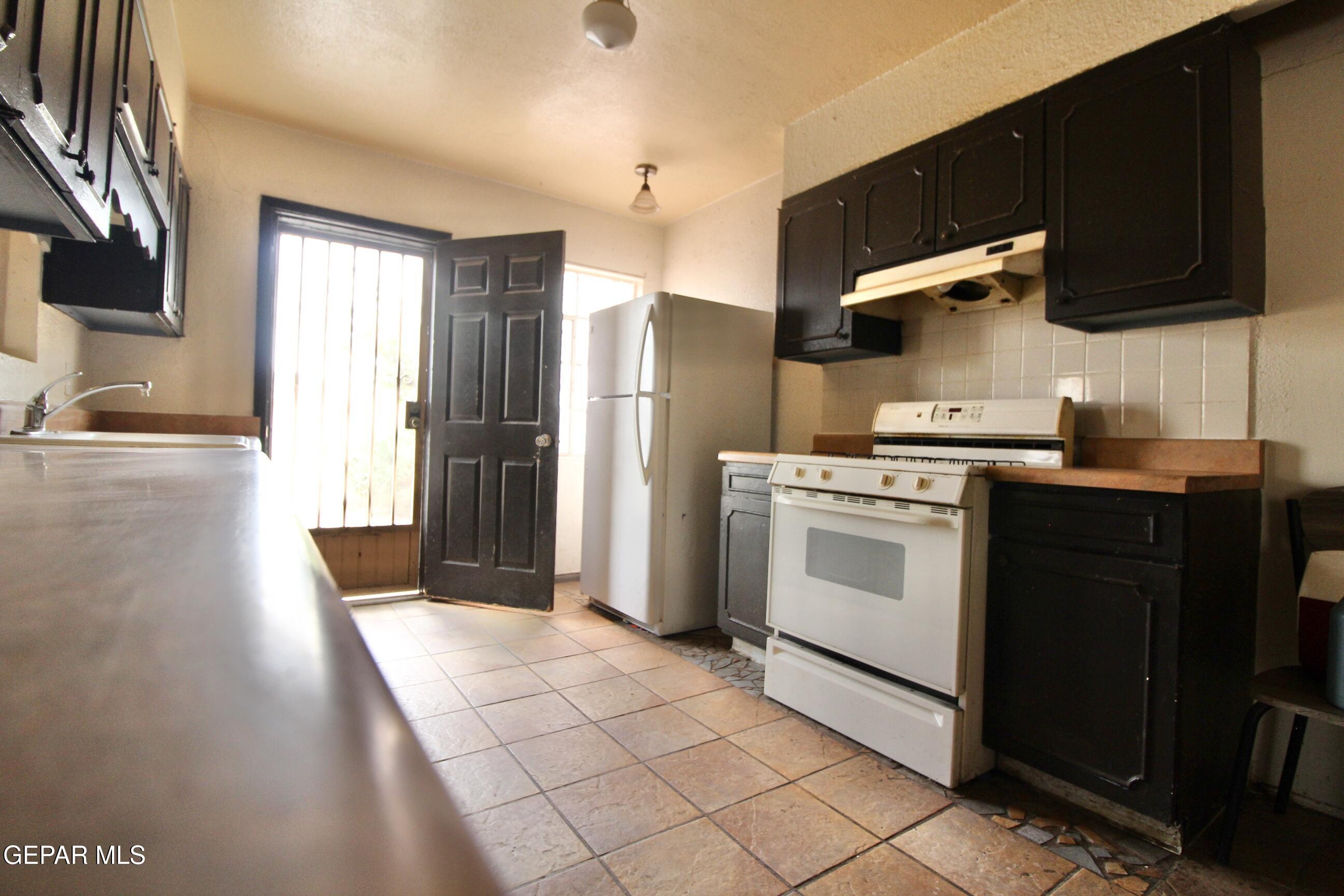 525 Margarita Street Anthony, TX 79821 - Photo 8 of 20 a kitchen with a stove top oven cabinets and a refrigerator
