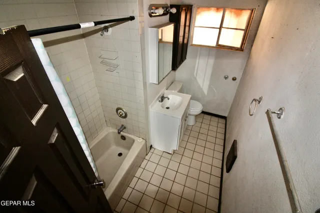 a bathroom with a sink a toilet a window and shower