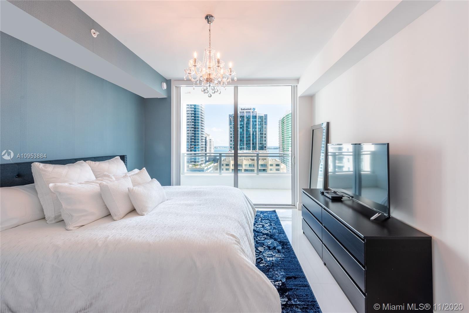 The Bond Miami, FL 33131 - Photo 6 of 19 a bedroom with a large bed and a chandelier