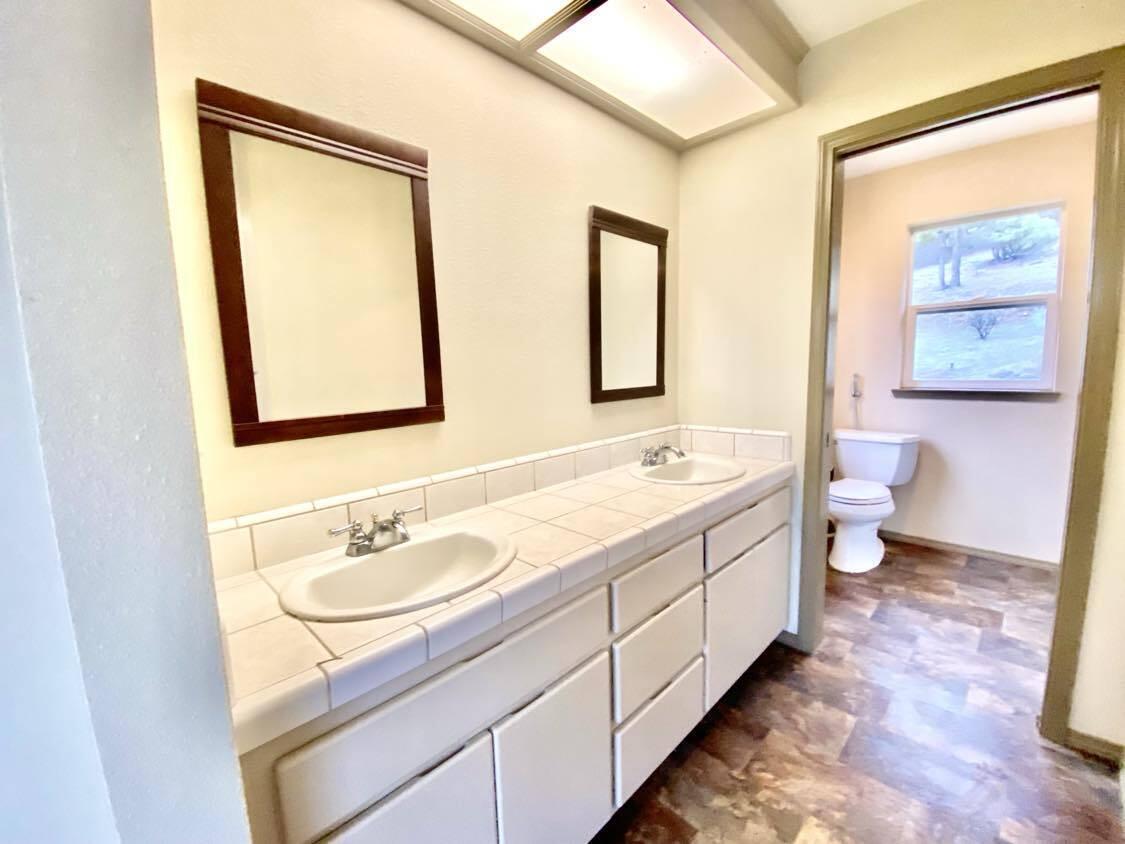 13080 Fern Road Whitmore, CA 96096 - Photo 29 of 49 a bathroom with a double vanity sink toilet and a mirror