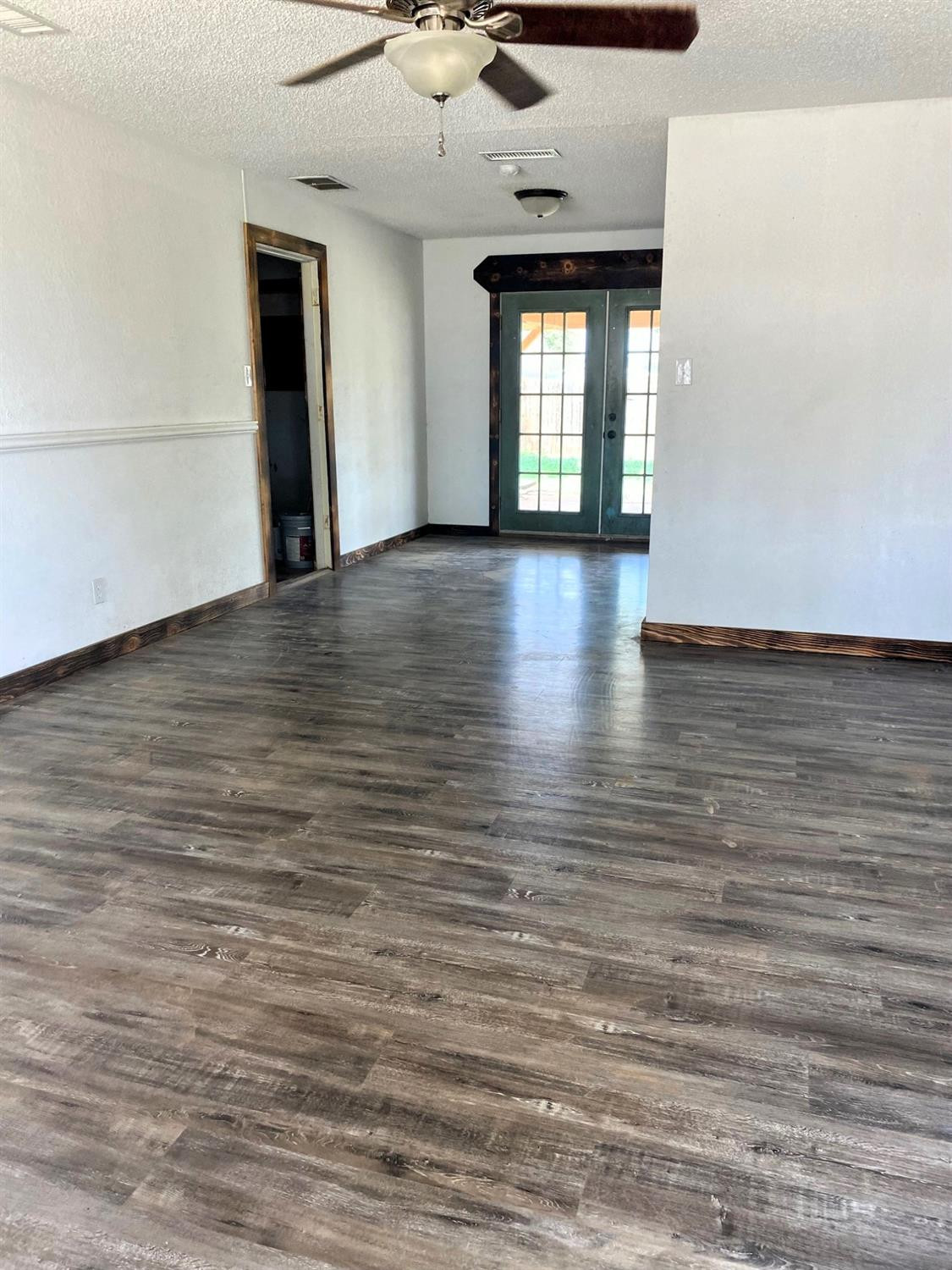 215 Darrell Street Levelland, TX 79336 - Photo 2 of 9 wooden floor in an empty room with a window