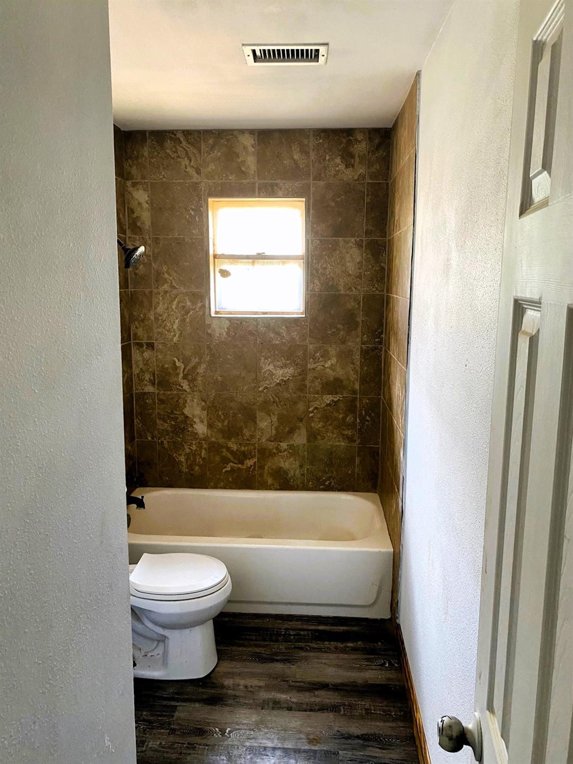 215 Darrell Street Levelland, TX 79336 - Photo 7 of 9 a bathroom with a toilet and a bathtub