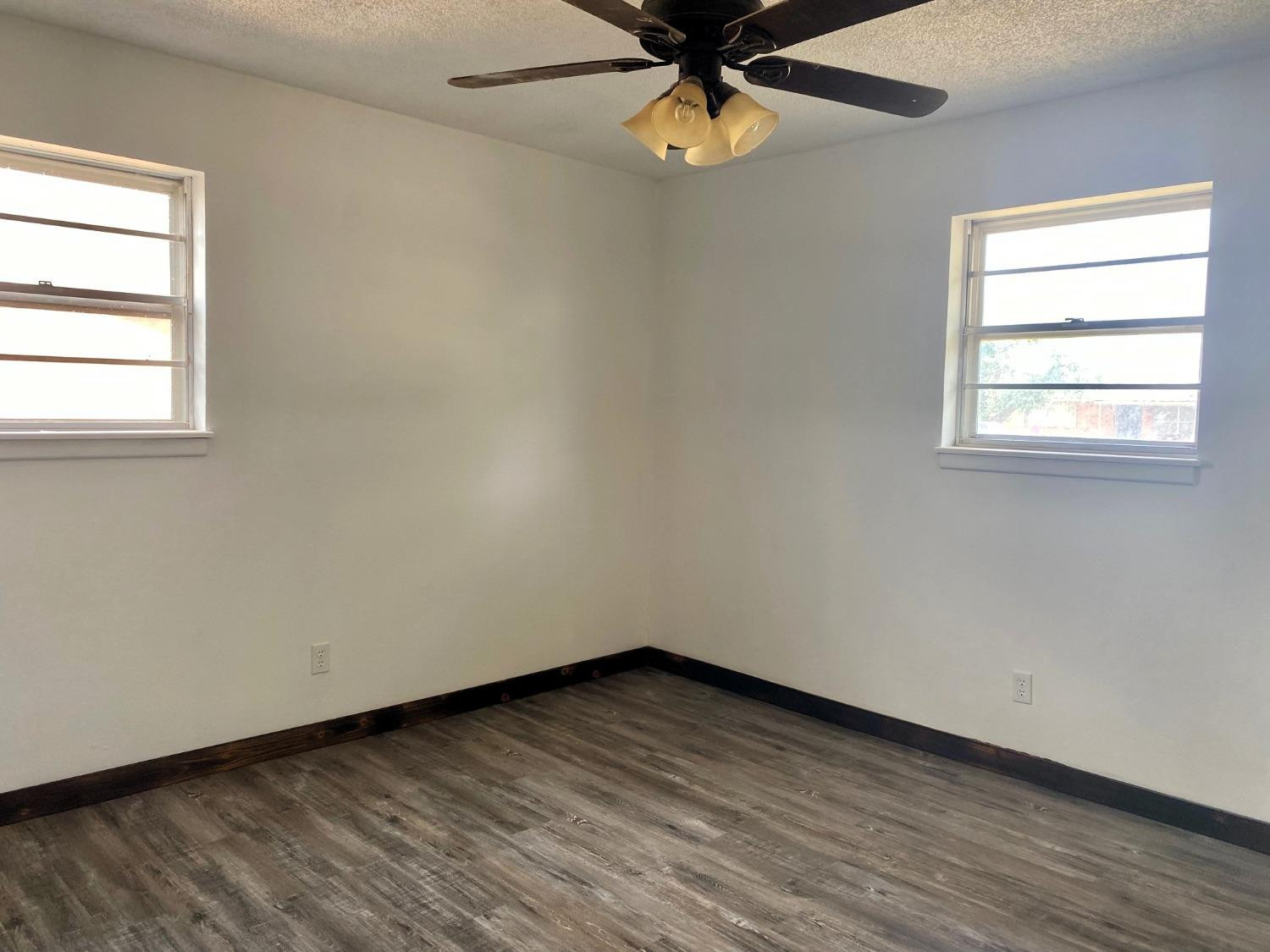 215 Darrell Street Levelland, TX 79336 - Photo 8 of 9 an empty room with a window and a fan