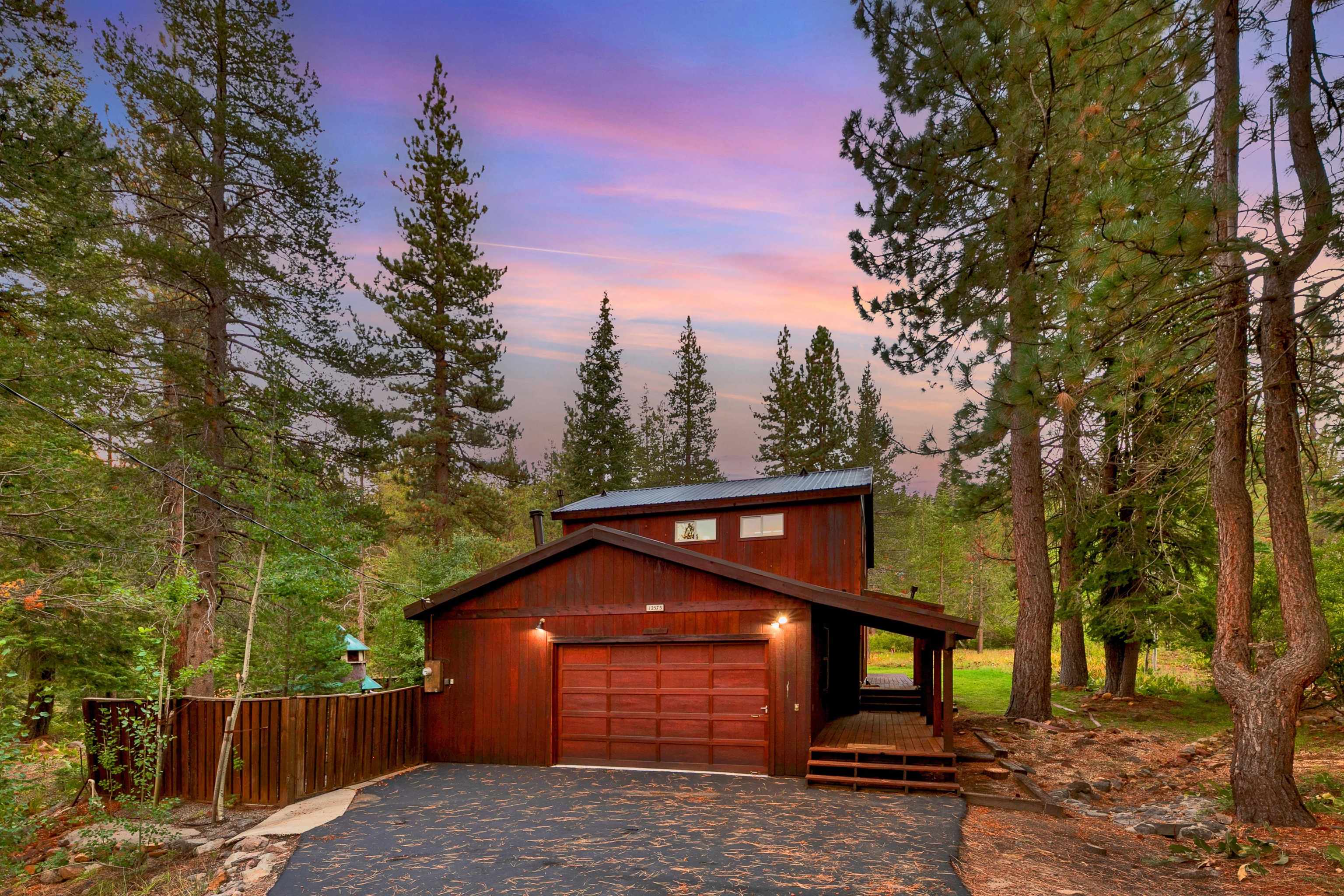 a front view of a house with a yard and tree s