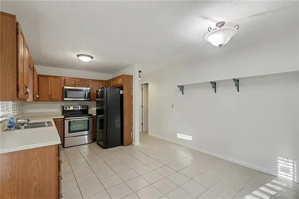 a kitchen with stainless steel appliances a refrigerator and a stove top oven