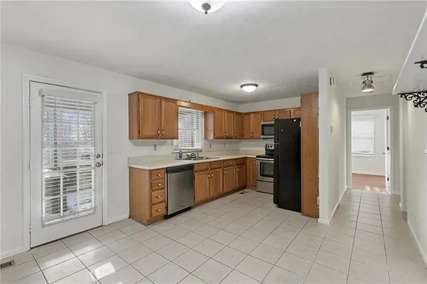a large kitchen with stainless steel appliances granite countertop a refrigerator and a sink
