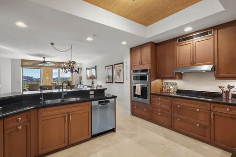 a kitchen with granite countertop a sink a counter space appliances and cabinets