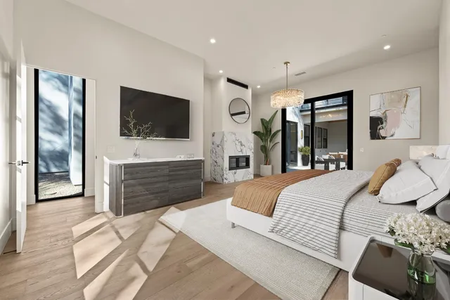 a bedroom with a large bed and a chandelier