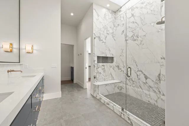 a view of an empty room with wooden floor and a bathroom