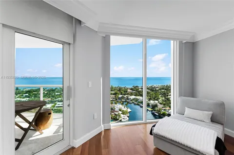 a room with a balcony a bed and a chair