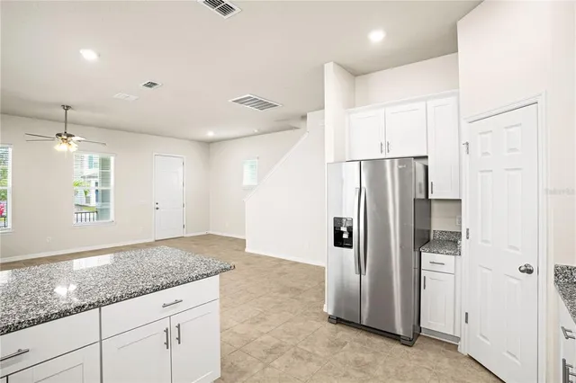 a kitchen with stainless steel appliances granite countertop a refrigerator and a sink