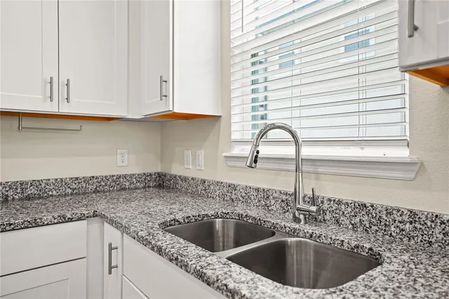 a kitchen with granite countertop a sink and a window