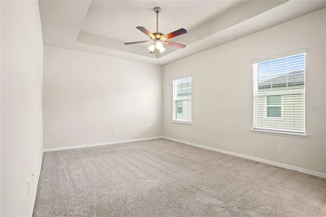 an empty room with window and ceiling fan